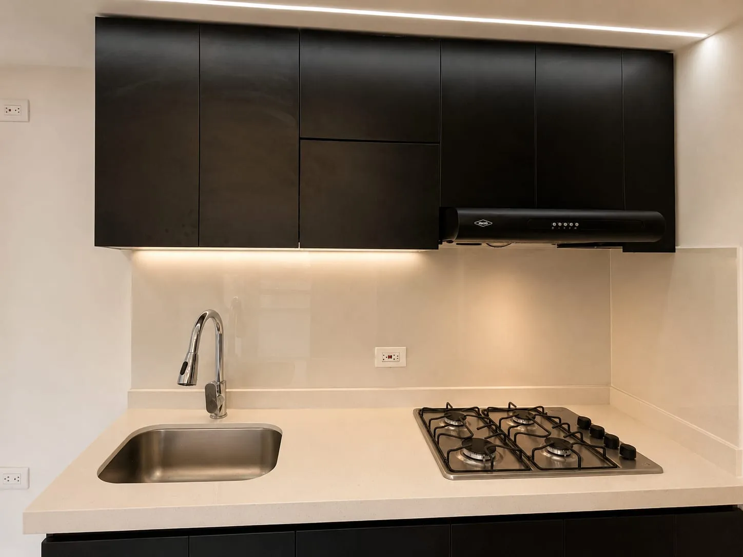 Una cocina de líneas depuradas y presencia refinada, donde la materialidad sobria y el diseño funcional convergen para ofrecer una experiencia estética elegante y confortable.